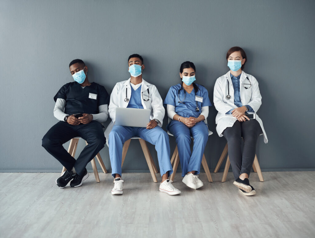 Shot of a group of doctors sitting against a grey background at work