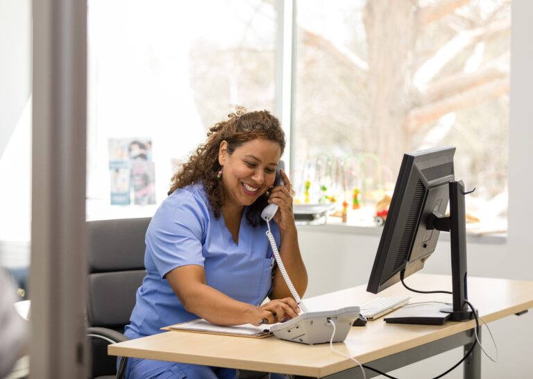 Cheerful female nurse makes patient calls in doctor's office