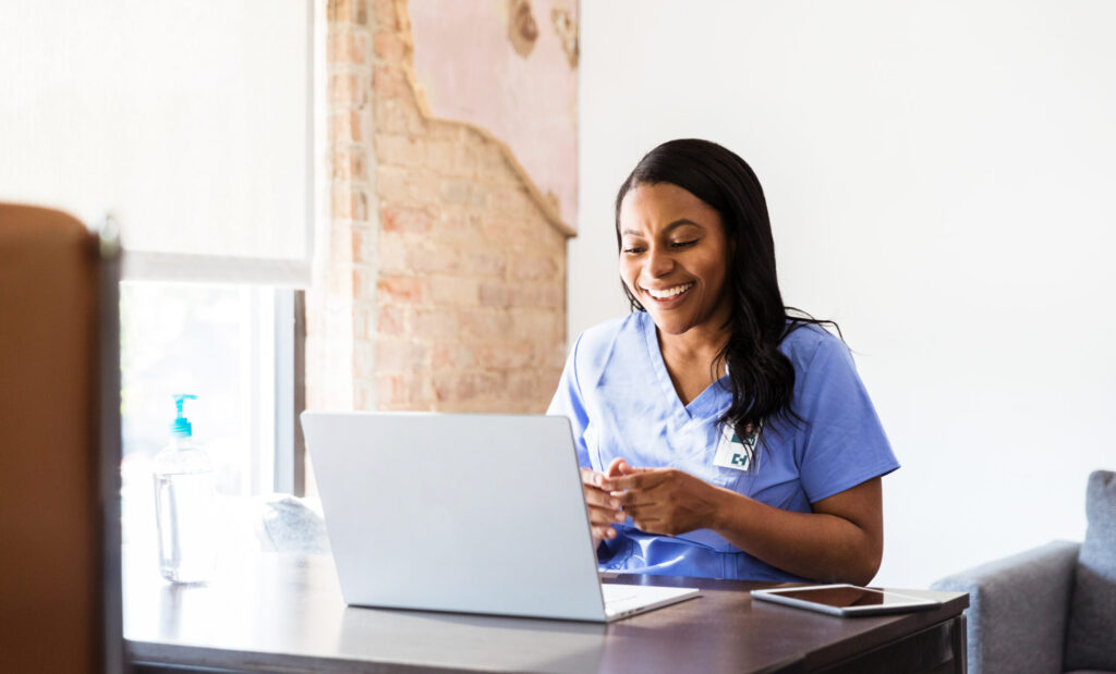 Happy doctor talks with patient during telemedicine appointment