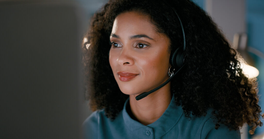 Woman, call center and night consulting in customer service, support or telemarketing at office. Face of female person consultant agent or virtual assistant working late in online advice at workplace