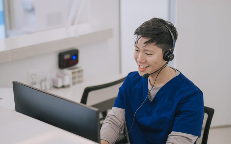 Hospital male nurse receptionist talking to patient at registration counter