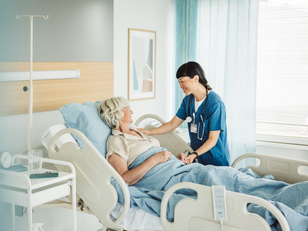 Senior woman in hospital bed with nurse