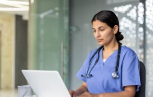Healthcare professional working on laptop in hospital