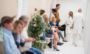 Many sick people wait in a busy hospital waiting room.